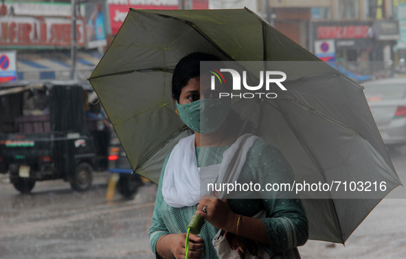 Local residents and others are seen on the road in daily market area as they are busy in their domestic works in between the rain weather in...