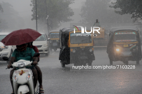 Local residents and others are seen on the road in daily market area as they are busy in their domestic works in between the rain weather in...