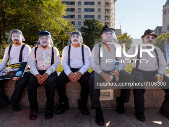 A group of men dressed as mimes await the beginning of a march for permanent residency for immigrants with temporary protected status in the...
