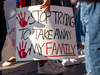 A teen carries a sign against family separation during a march for permanent residency for immigrants with temporary protected status in the...