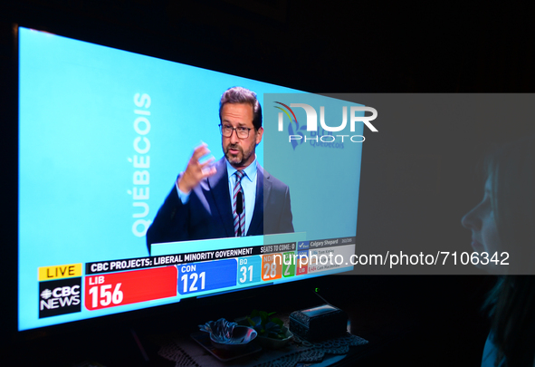 A woman watches Bloc Québécois leader Yves-François Blanchet speaking during a televised address on election night on CBC News.
Early electi...