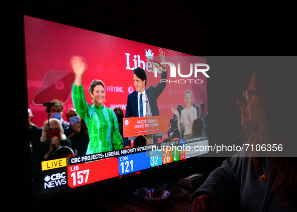A woman watches Liberal Party of Canada Leader Justin Trudeau celebrating with his family during a televised election night on CTV News.
Ear...