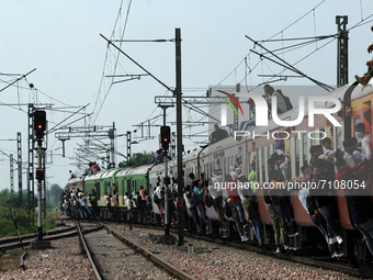 People travel in an overcrowded passenger train as it leaves a railway station amidst the spread of the coronavirus disease (COVID-19), at G...