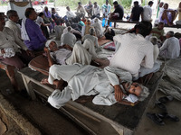 A farmer sleeps during the 'Zameen Samadhi' protest over three farm laws and an increase in land compensation, at Ghaziabad's Mandola villag...