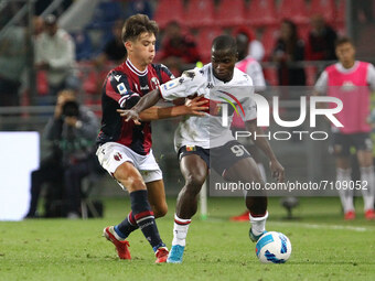 Aaron Hickey (Bologna F.C.) (left) competes for the ball with Yayah Kallon (Genoa CFC) during the Italian Serie A soccer match Bologna F.C....
