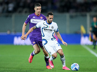 Hakan Calhanoglu of FC Internazionale and Nikola Milenkovic of ACF Fiorentina compete for the ball during the Serie A match between ACF Fior...