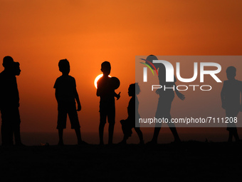 Palestinian boys play football during sunset in northern Gaza Strip, on September 21, 2021.
 (