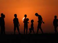 Palestinian boys play football during sunset in northern Gaza Strip, on September 21, 2021.
 (