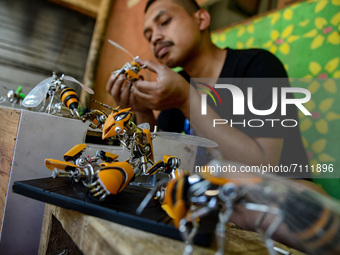 Yusuf (29) creating Transformers bee action figures in his home in Puncak, Bogor, West Java, Indonesia on September 22, 2021. Yusuf creates...