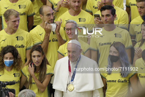 Pope Francis poses for a photo wearing an Olympic gold medal as he salutes Paralympic and Olympic athletes attending his weekly general audi...