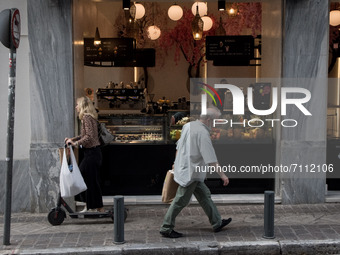 People seen walking front of a cafe in the center of Athens, Greece on September 22, 2021. (