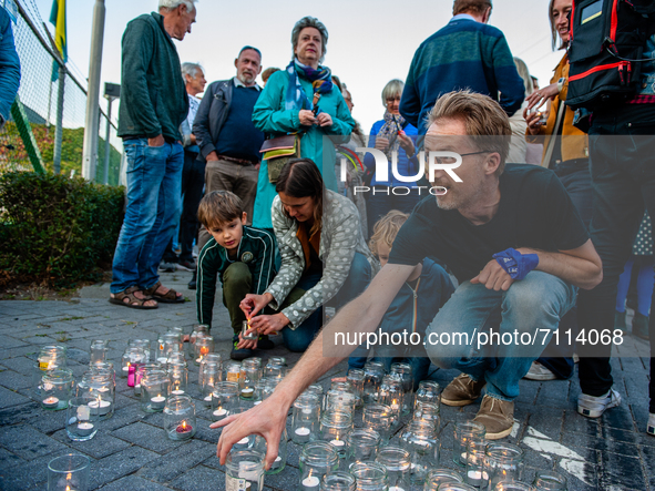 A man with a clothes peg putting on his nose because of the stink is leaving a candle in front of the factory, during the demonstration agai...