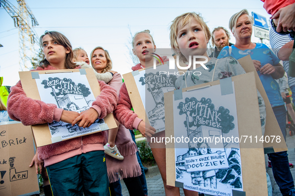 A group of children are holding placards that say in Dutch 'this factory stinks, makes our neighborhood very sick,' during a demonstration a...