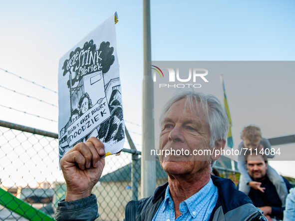 A man is holding a placard that say in Dutch 'this factory stinks, makes our neighborhood very sick', during a demonstration against the APN...