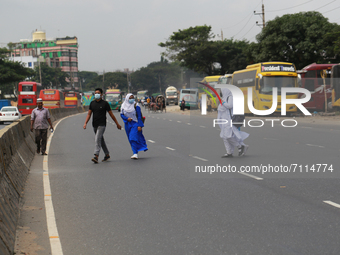 Students cross a highway in Dhaka, Bangladesh on September 22, 2021. (