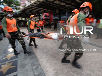 Libis, Quezon City Philippines - An injured man is rushed to an ambulance during the nationwide earthquake drill in Libis, Quezon City on Th...