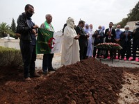 Mourners recite a prayer at the grave of Algerian politician Abdelkader Bensalah during his funeral at El-Alia cemetery in the capital Algie...