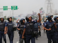 Law enforcers move towards garment worker protestors to displace them from Dhaka-Chattogram highway during a protest at Kanchpur in Narayang...