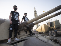 Young boys stand on a military tank in a war exhibition which is held and organized by the Islamic Revolutionary Guard Corps (IRGC) in a par...