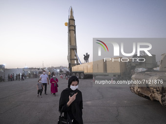 An Iranian woman walks along an area while visiting a war exhibition which is held and organized by the Islamic Revolutionary Guard Corps (I...