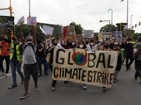 Protesters hold banners and placards as they participate in a march during a global climate strike as part of the 'Fridays for Future' movem...