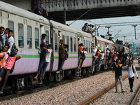 People travel in an overcrowded passenger train as it leaves a railway station amidst the spread of the coronavirus disease (COVID-19), at G...