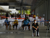People are waiting to be vaccinated against COVID-19 at a vaccination centre in Bangkok, set up at Bang Sue central railway station in Bangk...