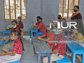 Primary section students wearing protective face mask attend their class after the Rajasthan government allowed schools to reopen for 1st to...