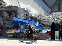 A Palestinian man  walks past the ruins of buildings destroyed in the lasted round of Israeli-Hamas fighting, in Gaza City,  on September 28...
