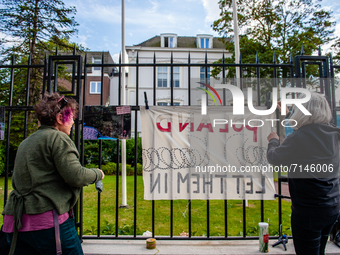 Two activists are placing in front of the Polish embassy a banner that says Let them in, during a demonstration in support of the refugees s...