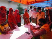 People wait to register for a dose of Covaxin, a coronavirus (COVID-19) vaccine, during a special vaccination camp in New Delhi, India on Se...