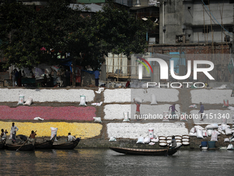 Workers spread recycled plastic chips after washing in the river Buriganga in Dhaka, Bangladesh on September 29, 2021. Buriganga River, whic...