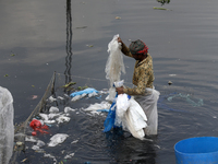A worker cleans polyethylene at the river Buriganga in Dhaka, Bangladesh on September 29, 2021. Buriganga River, which flows by Dhaka city i...