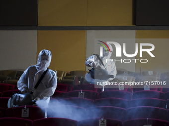 Shopping mall staff in hazmat suits disinfect a cinema inside a major shopping mall in Bangkok, Thailand, 01 October 2021. (