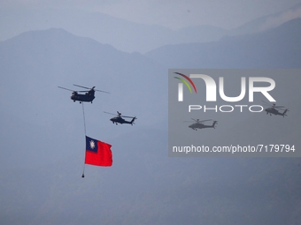 A military helicopter carrying a tremendous Taiwan flag flies over near  Taipei 101, as part of the rehearsal ahead of the Double-tenth nati...
