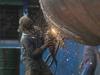 A dockyard worker carries maintenance work on a ship in Keraniganj on October 2, 2021. (
