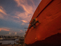 A dockyard worker wealds on a ship as part of maintanence in Keraniganj on October 2, 2021. (
