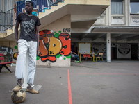 A young migrant playing football in the courtyard of the Jean Quarré school in Paris on 2015/08/04. Since friday, the migrants occupy the je...