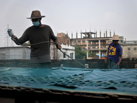 A worker sprays colored chemicals on a piece of leather at a tannery in Hazaribag, Dhaka, Bangladesh on October 06, 2021. Though many leathe...