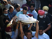 SRINAGAR, KASHMIR, INDIA-OCTOBER 07: People carry the body of school principal Satinder Kaur in the premises of her residence in Allocha Bag...