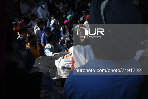 Sikh mourners sit around the dead body of the slain school principal Supinder Kaur in Srinagar, Indian Administered Kashmir on 8 October 202...