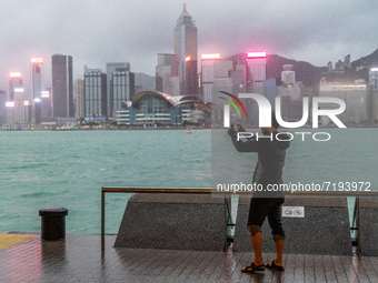 A man films Victoria Harbour as typhoon warning signal 8 has been in force for most of the day, in Hong Kong, China, on October 9, 2021.  (