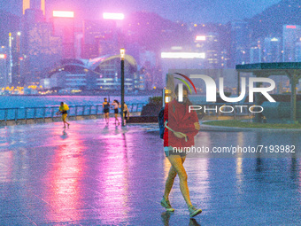  A young lady moves to take shelter from the train in Tsim Sha Tsui, in Hong Kong, China, on October 9, 2021.  (