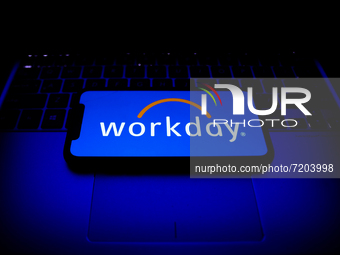 Workday logo displayed on a phone screen and a laptop keyboard are seen in this illustration photo taken in Krakow, Poland on October 11, 20...