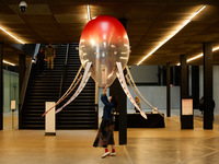 A member of staff takes down one of the helium-filled, rotor-propelled 'aerobes' forming artist Anicka Yi's 'In Love With The World' in the...