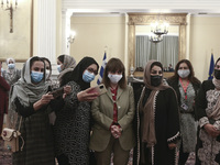 Afghan women, part of a group of lawyers and judges who fled Afghanistan following the Taliban takeover, at the presidential mansion, take a...