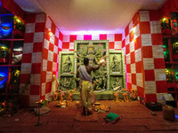 A priest is seen in worship of an idol of Goddess Durga at a pandal , during Durga puja festival in Kolkata , India , on 12 October 2021 . (