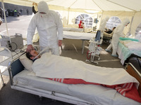 Activists stage an art-performance with a scene of temporary resuscitation department for COVID-19 patients during a 'Vaccinate our world' (...