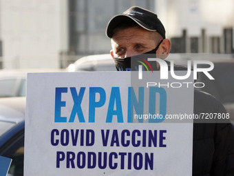 An activist holds a poster during a 'Vaccinate our world' ('VOW') rally, demanding of abandoning Covid-19 vaccine patents, near the European...