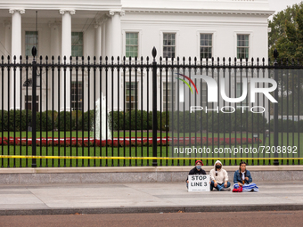 Climate activists await arrest at the White House during a civil disobedience action against the continued use of fossil fuels, on the secon...